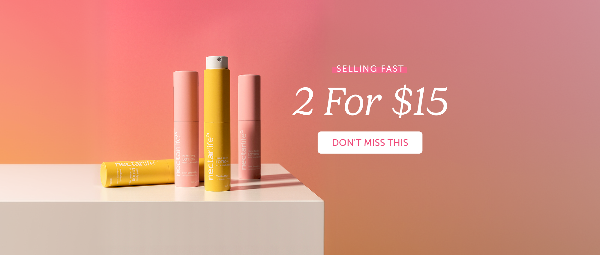 Four Nectar Life Hand Spray Lotion with Sunflower tubes in Fruit Smoothie and Vanilla Musk scents arranged on a white surface against a warm coral-to-pink gradient background. Text reads: Selling Fast — 2 For $15.