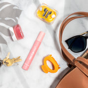 Nectar Life Custom Fragrance Mist in pink spray bottle alongside handbag and sunglasses, portable non-comedogenic body fragrance mist with safflower oil, handmade in USA