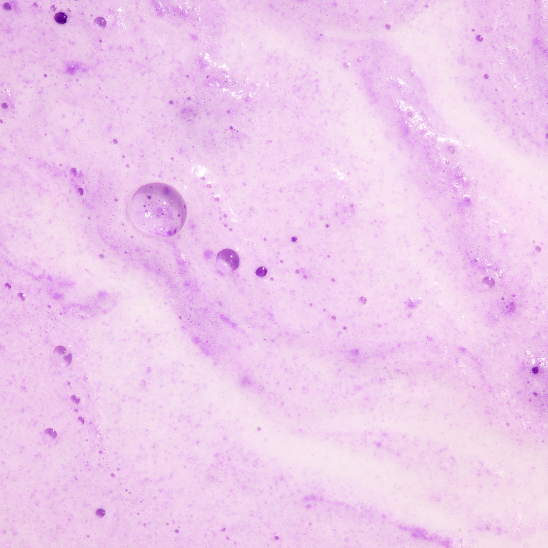 Milkshake Bath Soak Lavender Blossom dissolved in bath water, purple fizzing texture close-up, foaming and moisturizing