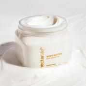Nectar Life Shea Body Butter in Vanilla Sugar, 16 oz clear jar with gold lettering open to reveal thick creamy off-white whipped body butter swirled on top, made with shea butter, vegan and plant based, handmade in Las Vegas