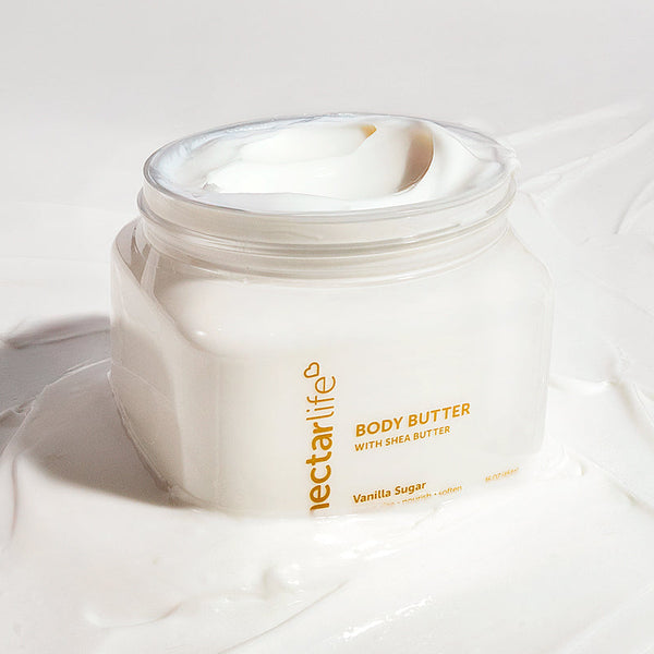 Nectar Life Shea Body Butter in Vanilla Sugar, 16 oz clear jar with gold lettering open to reveal thick creamy off-white whipped body butter swirled on top, made with shea butter, vegan and plant based, handmade in Las Vegas