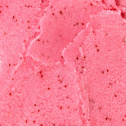 Close up texture shot of Nectar Life Fruit Smoothie Sugar Body Scrub showing bright pink granules with red berry flecks