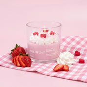 Strawberry Crème Coconut Wax Candle by Nectar Life lit and styled with fresh strawberries and whipped cream on a pink gingham background, 14oz