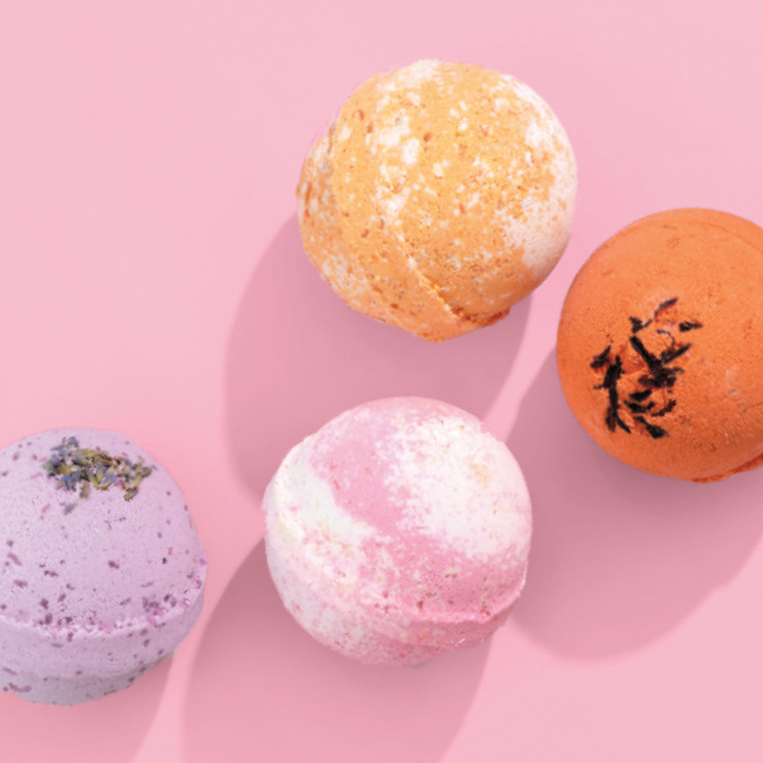 Nectar Life Round Bath Bombs in Peaches 'n Cream, Exotic Acai, Lavender Blossom on a pink background, handmade in Las Vegas with Epsom salt and bentonite clay