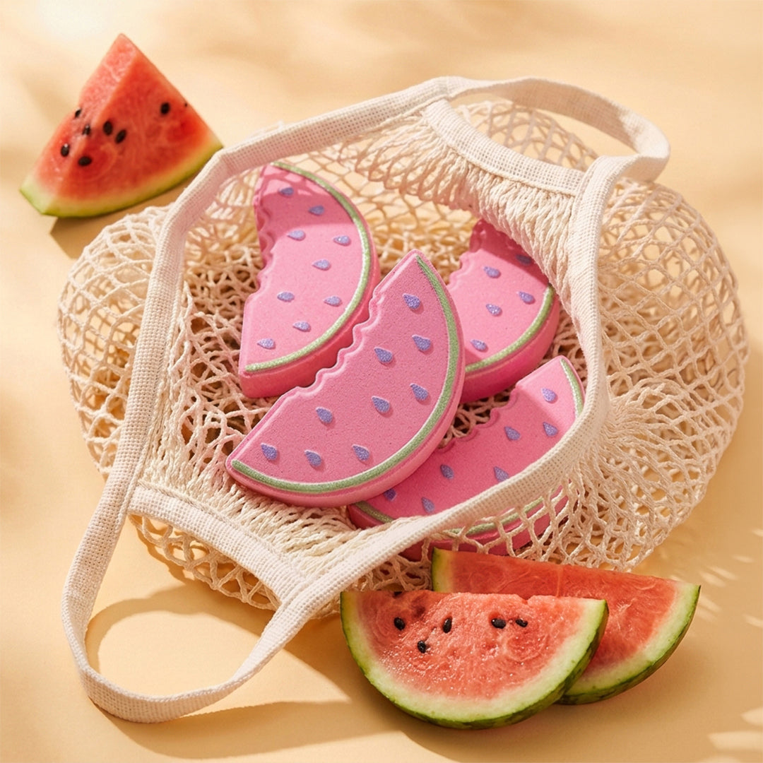 Nectar Life Fresh Watermelon Slice Bath Bombs in a cream mesh tote bag surrounded by fresh watermelon pieces on a warm golden background