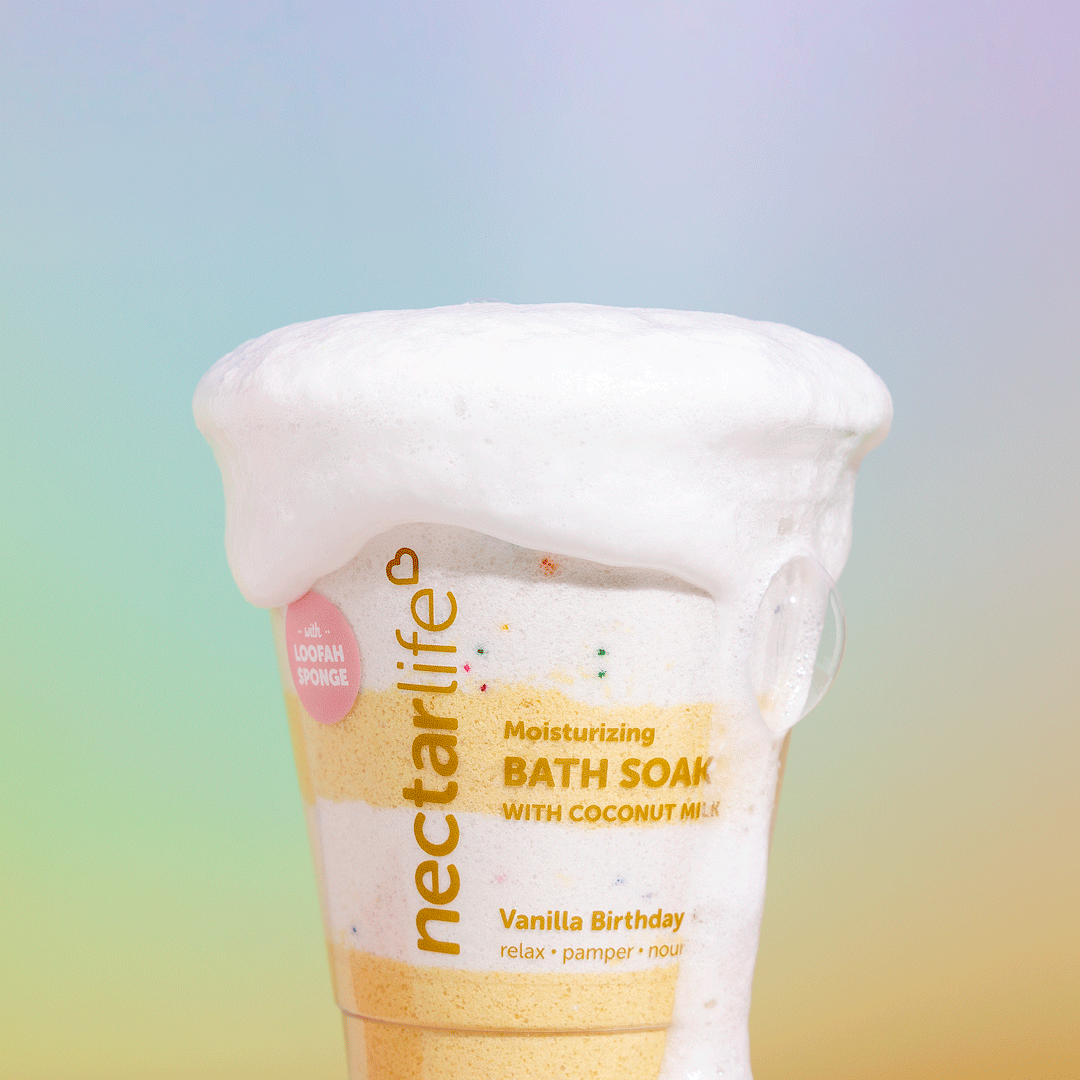 Nectar Life Moisturizing Milkshake Bath Soak in Vanilla Birthday Cake, foaming in warm bath water, yellow and cream swirling color
