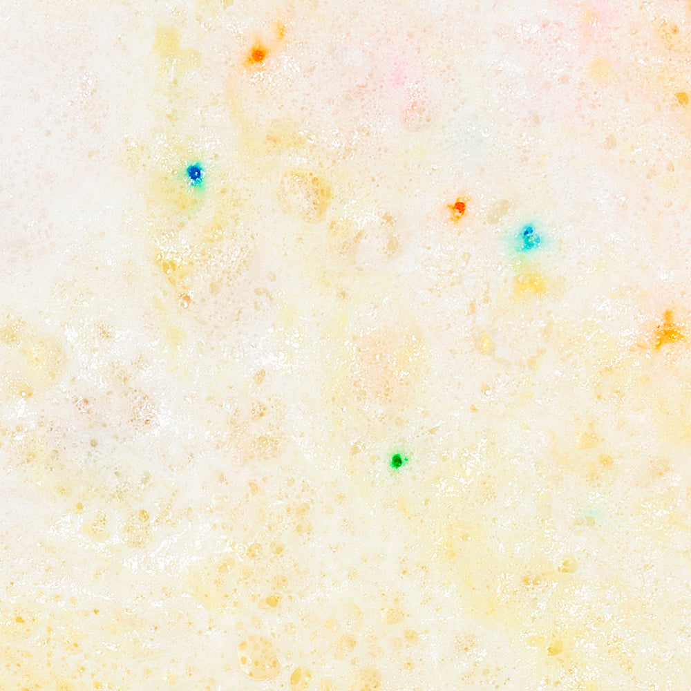 Milkshake Bath Soak Vanilla Birthday Cake dissolved in bath water, yellow fizzing texture close-up, foaming and moisturizing